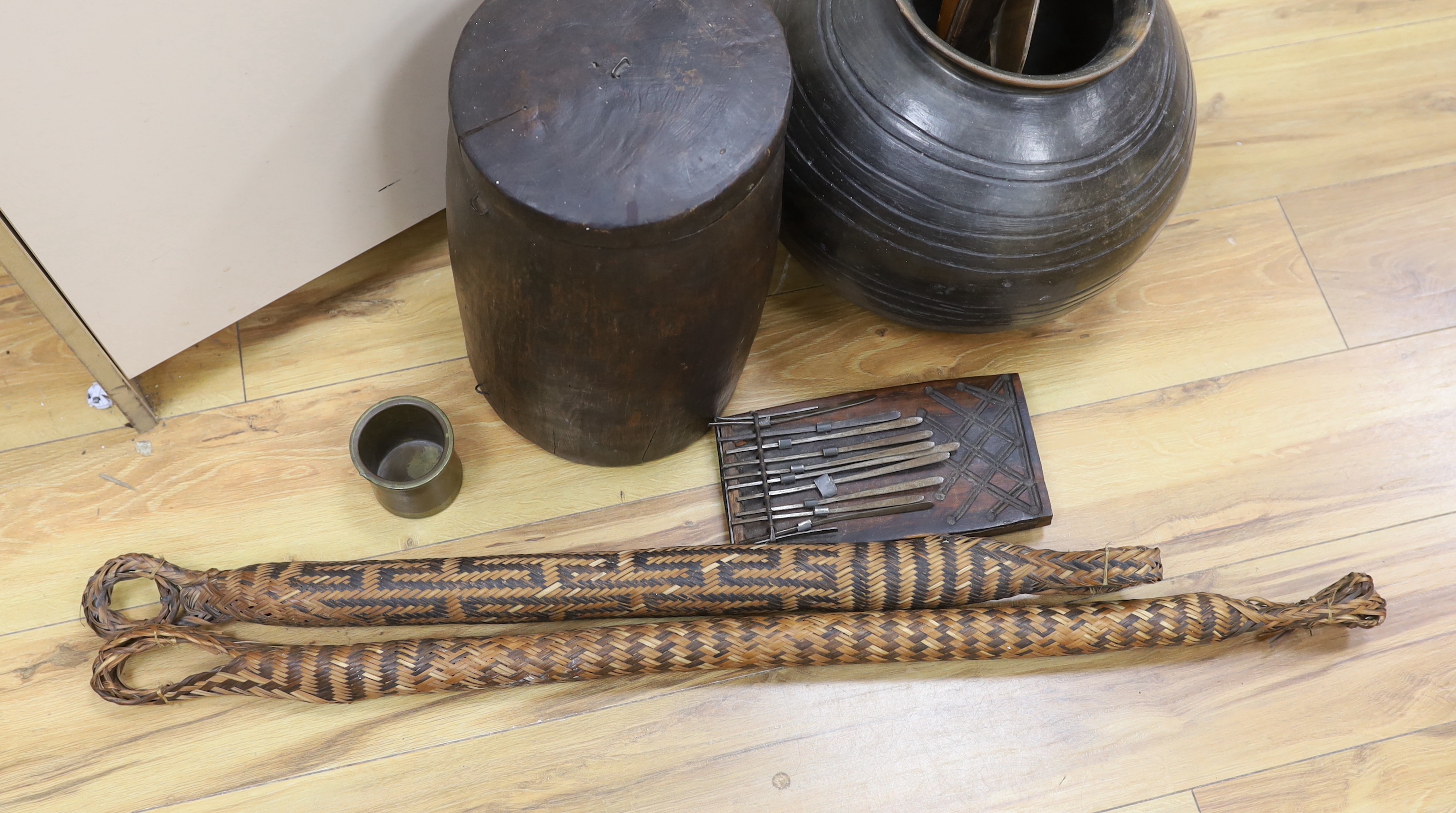 An earthenware bowl, two woven arrow quivers, a bronze pot, a wooden pot and lid, a fertility figure, two boomerangs, etc. (9)